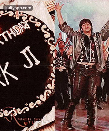 a man in a leather jacket is standing next to a birthday cake