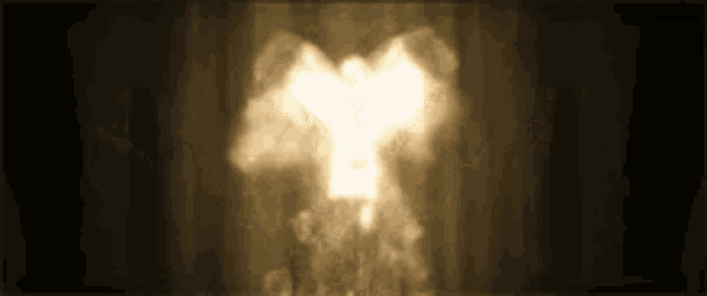 a silhouette of an angel is surrounded by smoke on a dark background
