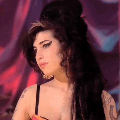 a woman with a tattoo of a horseshoe on her arm looks to the side
