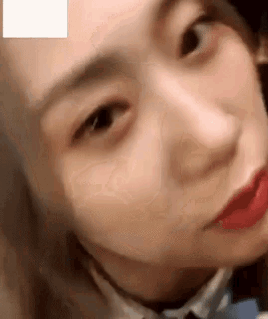 a close up of a woman 's face with red lipstick on .