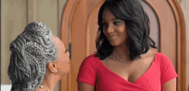 two women are standing next to each other and smiling at each other