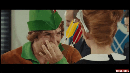 a man in a robin hood costume covering his nose