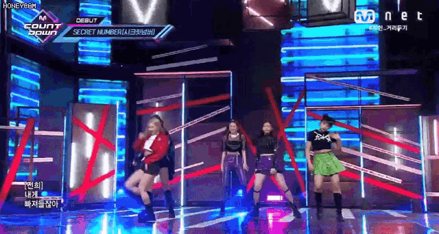 a group of girls are dancing on a stage in front of a mnet advertisement