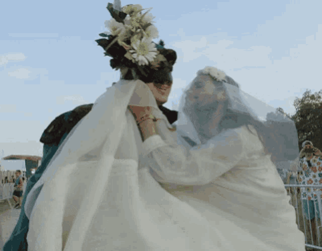 a woman in a veil is holding another woman in a veil