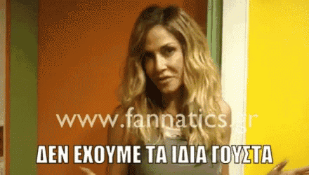 a woman is standing in front of a yellow wall with the website www.fannatics.gr