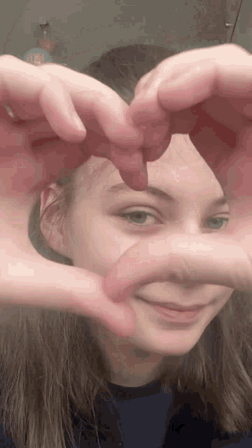 a girl making a heart shape with her fingers
