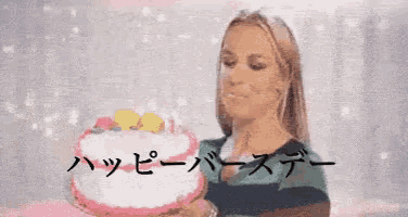 a woman is blowing out a candle on a birthday cake while holding a tray .