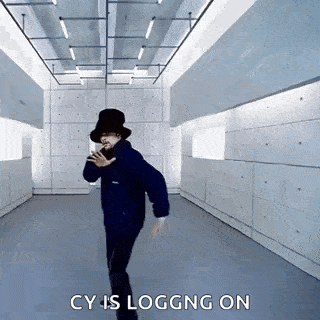 a man in a black hat is dancing in a room with the words `` cy is logging on '' written on the bottom .