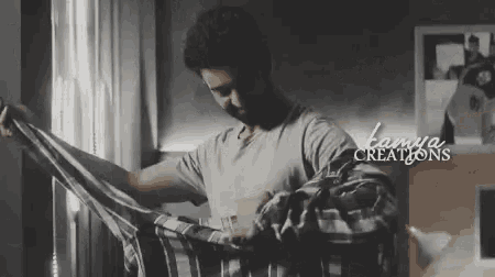 a man is putting on a plaid shirt with tanya creations on the bottom