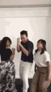 a group of people are dancing in a room .