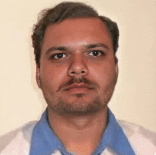 a man with a beard wearing a white shirt and blue collar