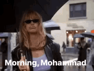 a woman is holding an umbrella in the rain and says morning , muhammad