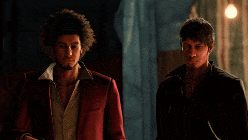 a man in a red suit stands next to another man in a black jacket