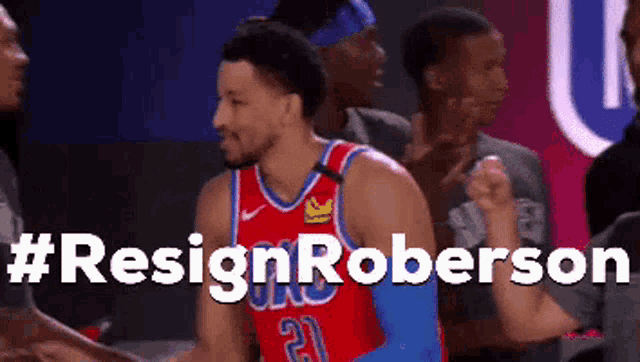 a basketball player with the number 21 on his jersey shakes hands with another player .