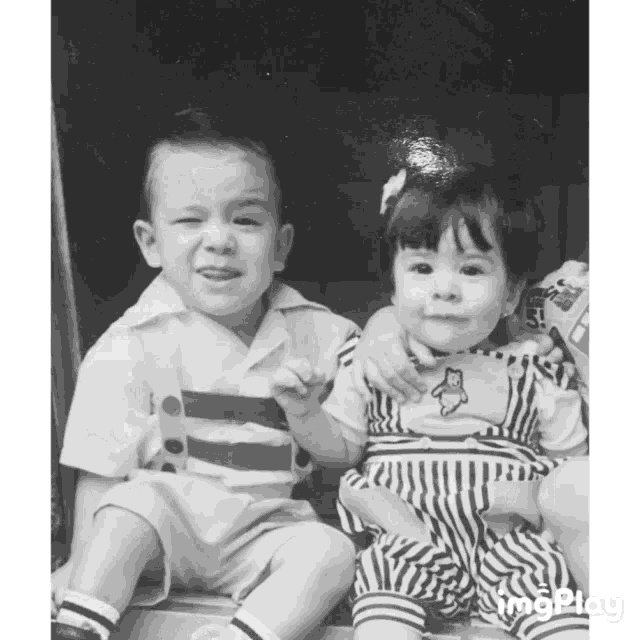 a boy and a girl are sitting next to each other in a black and white photo with the caption imgplay