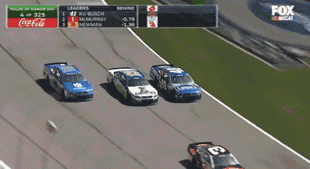 three race cars are on a race track with a coca-cola advertisement