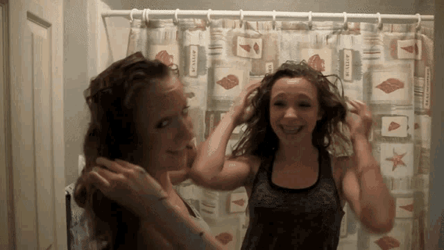 a shower curtain with seashells on it hangs on a shower rod