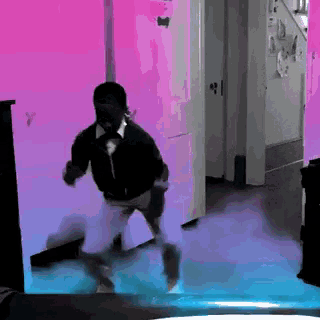 a man in a black jacket is dancing in a room