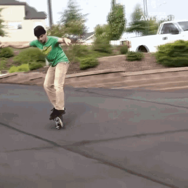 a man in a green shirt is riding a skateboard in a parking lot