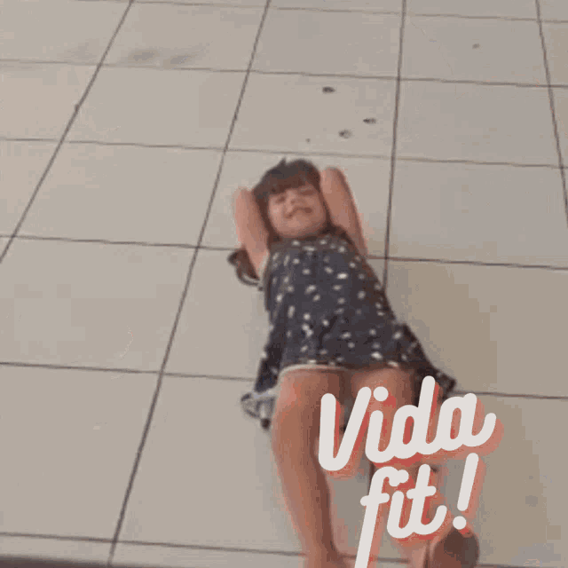 a little girl is laying on the floor with the words vida fit written on the bottom
