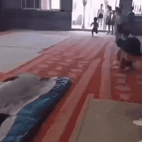 a little boy is running down a red carpet .