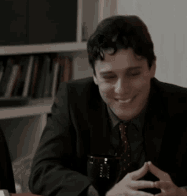 a man in a suit and tie is smiling at the camera