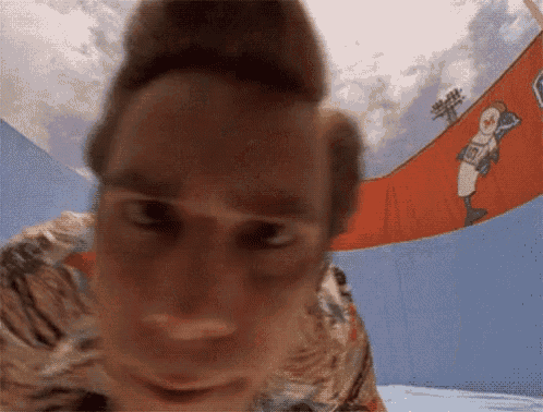 a close up of a man 's face with a baseball player on the wall