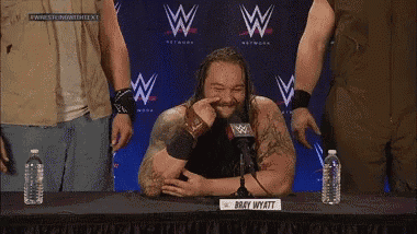 a man with long hair is sitting at a table with a sign that says bryan hyatt