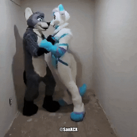 two furry costumes are hugging each other in a corner .