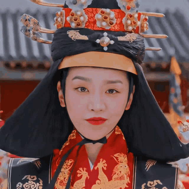 a woman wearing a red and black costume and a black hat