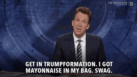 a man in a suit and tie is talking on a news channel about trump .