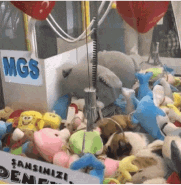 a claw machine filled with stuffed animals and a sign that says mgs on it
