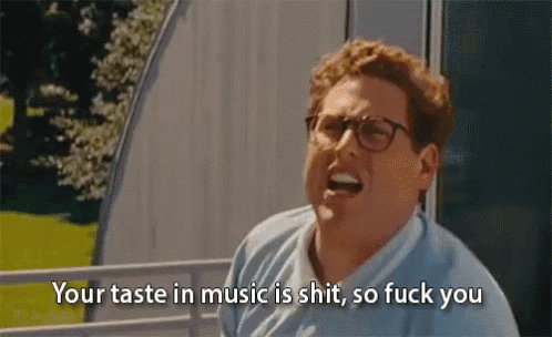 a man wearing glasses is saying your taste in music is shit so fuck you .
