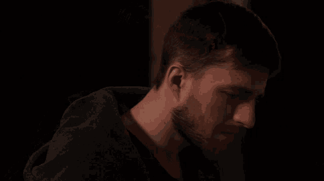 a blurry picture of a person 's face in a dark room with a light shining through the window