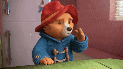 paddington bear wearing a red hat and blue coat