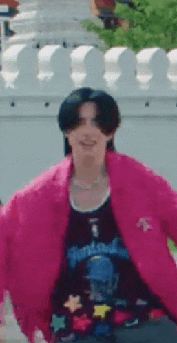 a man is wearing a pink jacket and a black shirt .