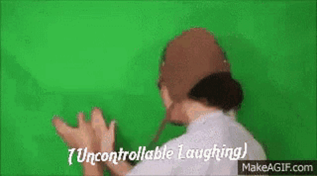a person is laughing on a green screen while wearing a hat .
