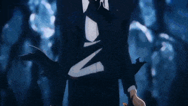 a man in a suit and tie is standing in a dark forest holding a sword .
