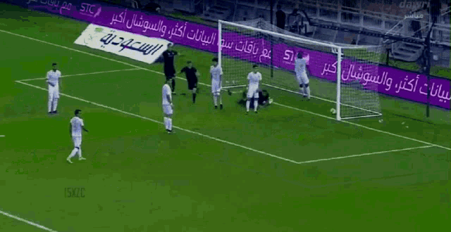 a soccer player is celebrating after scoring a goal in front of a purple sign that says stc
