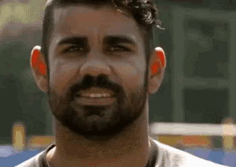 a man with a beard is smiling at the camera .