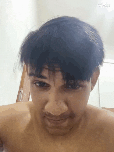 a man without a shirt is making a face with his hair blowing in the wind