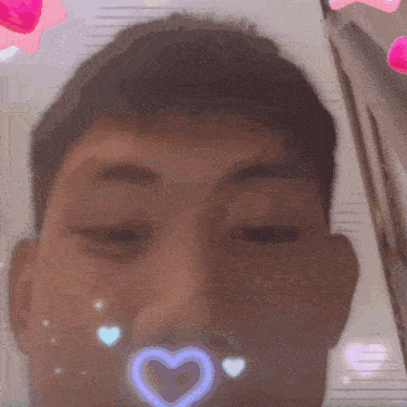 a close up of a man 's face with hearts and a heart in his mouth