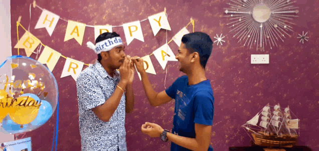 a man wearing a happy birthday headband is blowing a party horn