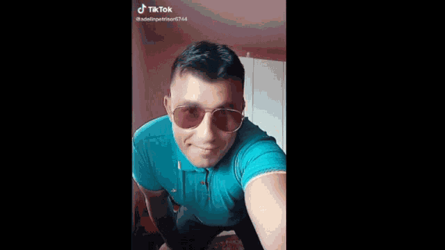 a man wearing sunglasses and a blue shirt is dancing on a tiktok video