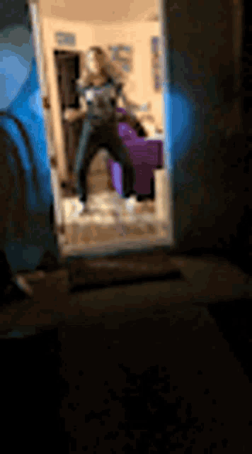 a woman is dancing in front of a mirror in a dark room .
