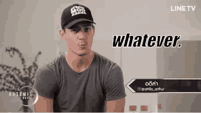 a man wearing a hat and a t-shirt is making a funny face and says whatever .