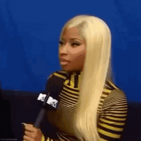 a woman with blonde hair is holding a microphone in her hand .