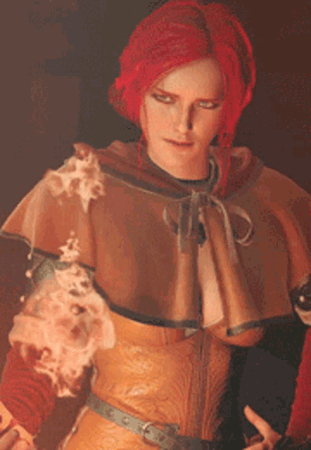 a woman with red hair and a cape is holding a fireball