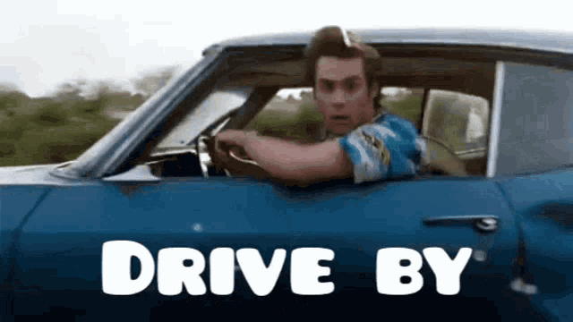 a man is driving a blue car that says drive by on the side