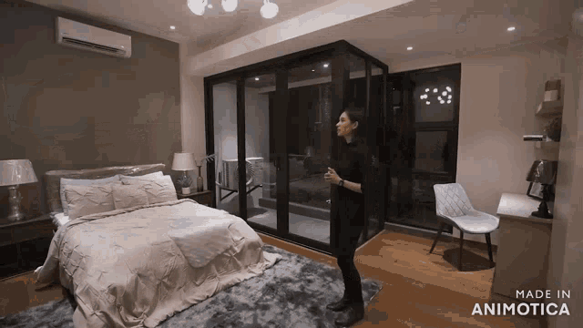 a woman stands in a bedroom with the words made in animotica on the bottom
